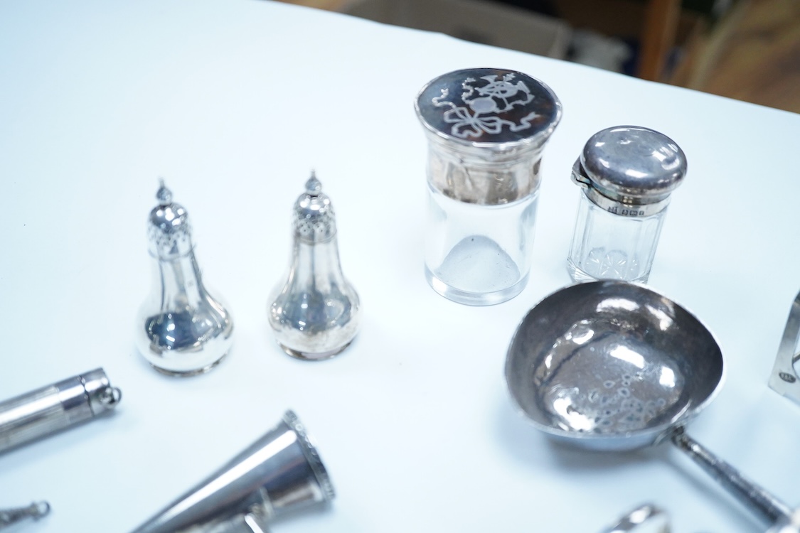 A group of assorted silver, to include a pair of modern five bar toast racks, a George V card case, a sterling vesta case, four assorted condiments, two mounted toilet bottles, mounted timepiece, a modern wooden handled